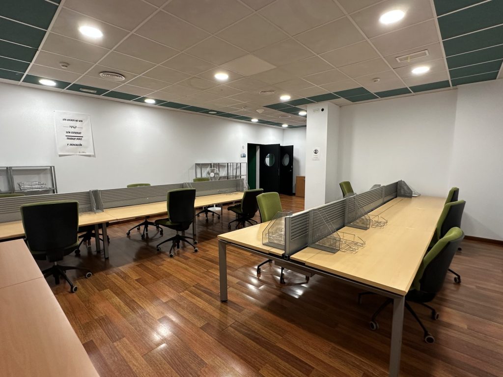 Sala común de coworking con puestos de trabajo y sillas ergonómicas